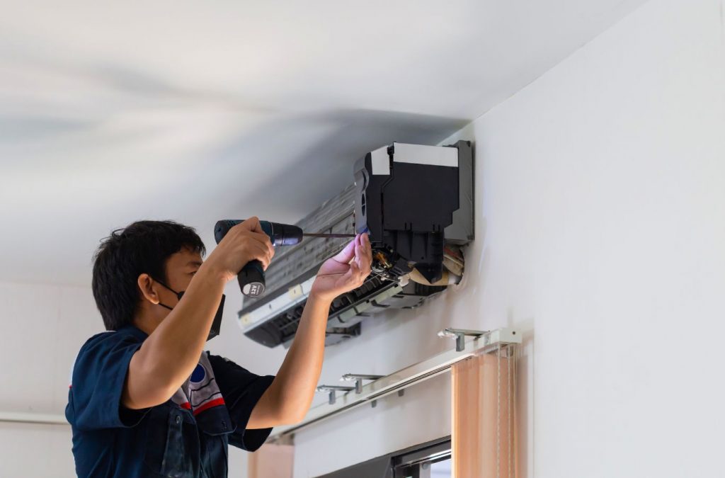 A Climate Systems employee performing AC installation in Gibsonia, PA, using professional tools to ensure optimal cooling performance.