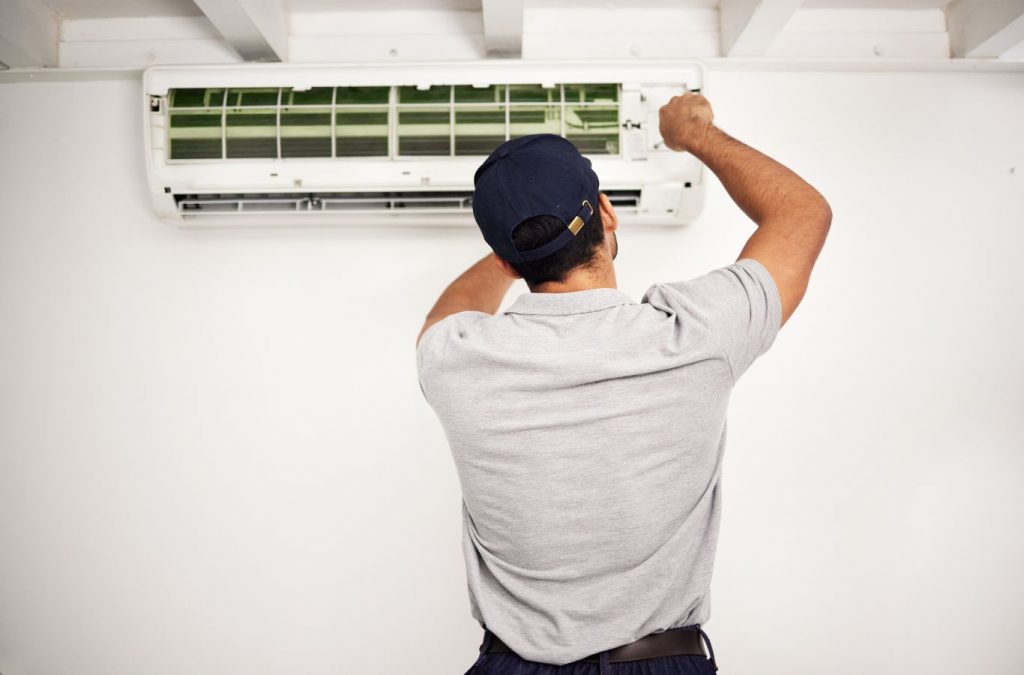 A Climate Systems employee performing AC installation in Hampton Township, PA, using professional tools to ensure reliable and efficient service.