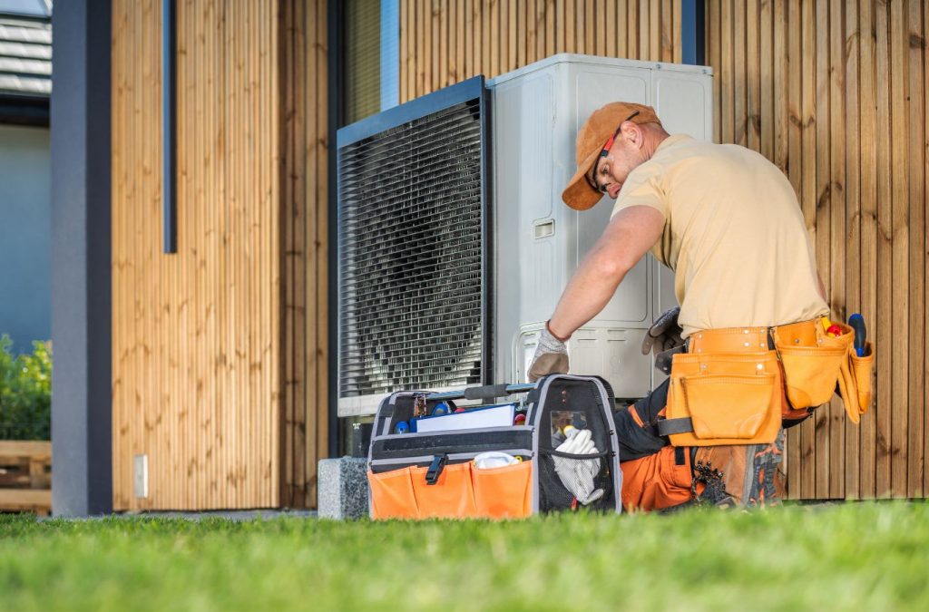 A Climate Systems technician repairing a heat pump in Adams Township, PA, showcasing skilled service and tools used for restoring HVAC performance.